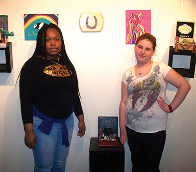 Two female GPA students with their artworks displayed at Virtua Hospital