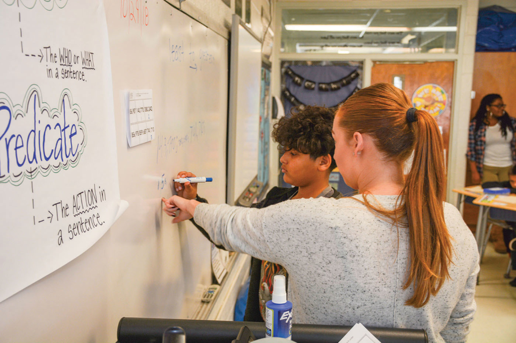 Ms. Jessica Jones working one on one with a male student on math board problems