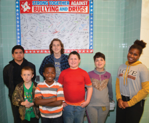 GPA student council members standing in front of a anti bullying and anti drug poster with many student signatures