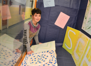 Female student council member decorating a display case at Garfield Park Academy