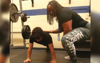GPA staff working with a male student in the new Therapeutic Weight Room