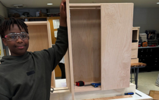 Male GPA student displaying a cabinet he build in carpentry as part of his transition programs